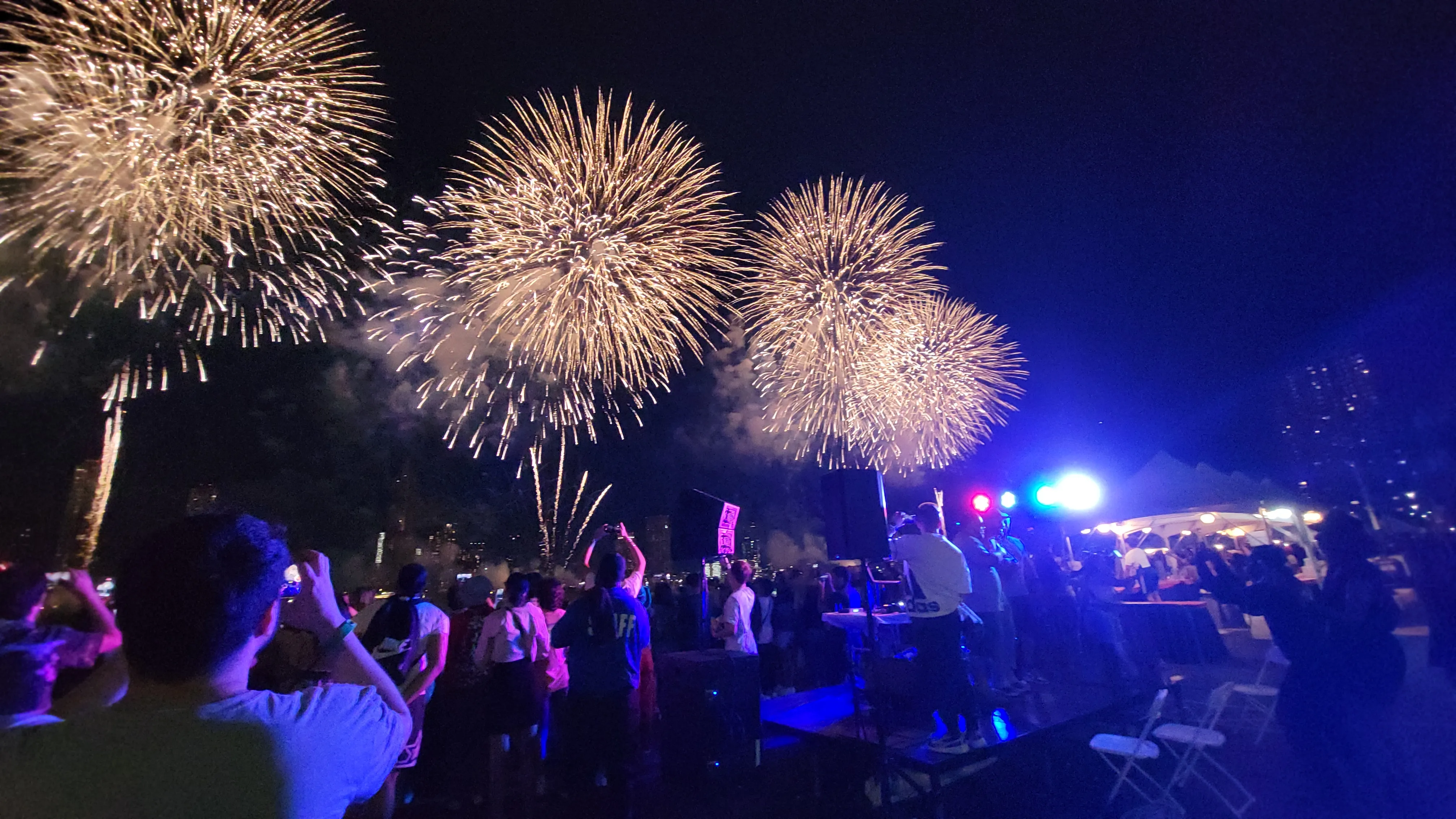 Golden fireworks with celebrating crowd and event infrastructure