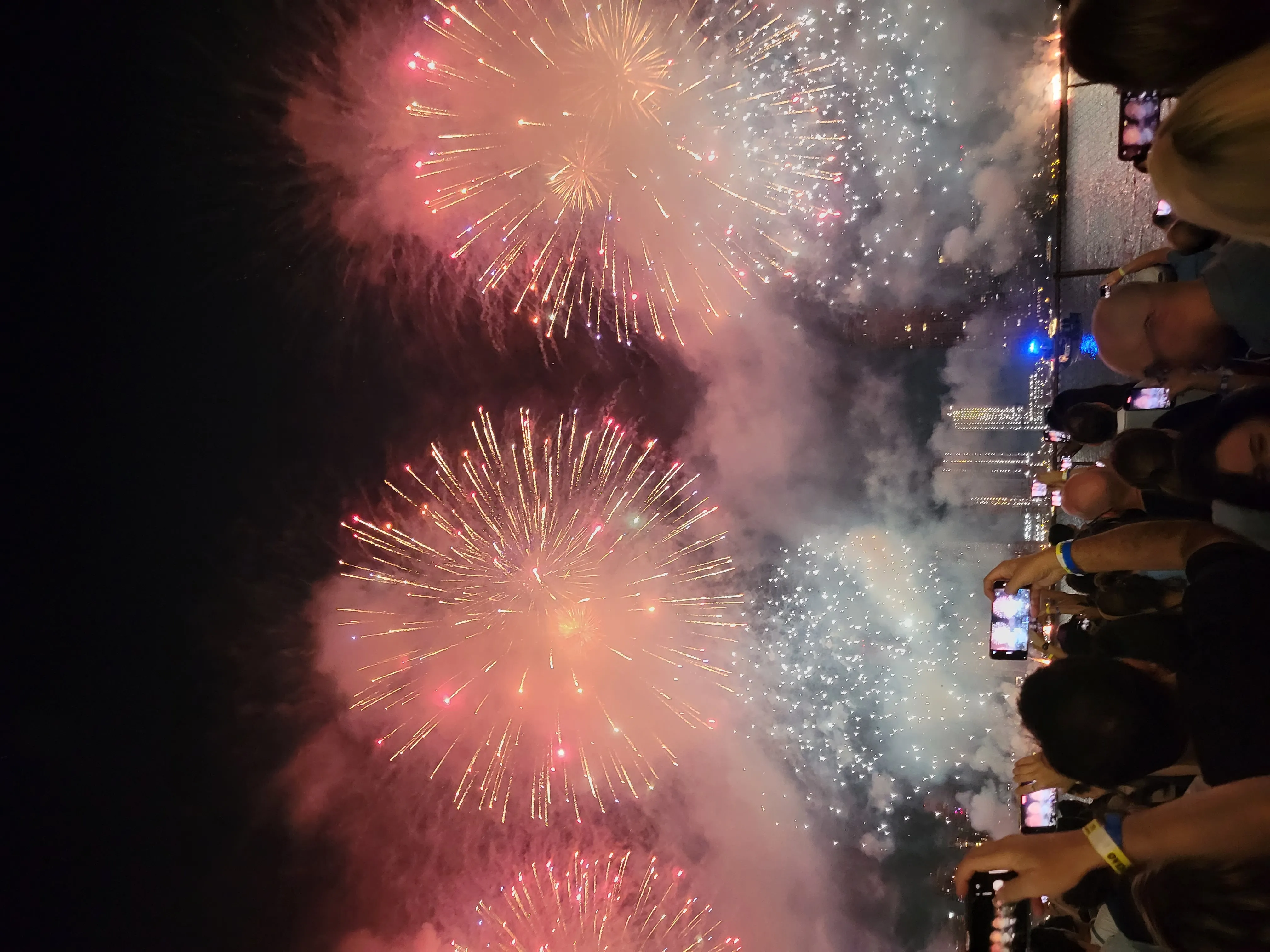 Close-up red and white fireworks with crowd taking photos